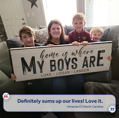 Tailored Canvases canvas sign reading home is where my boys are held by a smiling family on Tampa Home & Garden Store