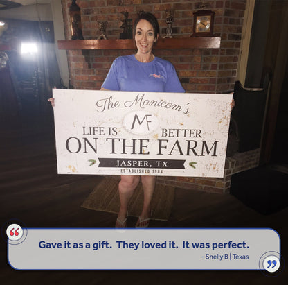 Life Is Better On The Farm Sign canvas held by a smiling woman; rustic distressed white sign on Tampa Home & Garden Store