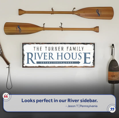 Family River House Arrow Sign Canvas sign with blue text beside paddles in Tampa Home & Garden on Tampa Home & Garden Store