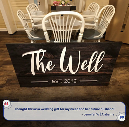 Wooden family name sign on dark wood with white cursive text EST. 2012 by Tailored Canvases on Tampa Home & Garden Store