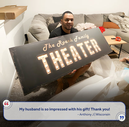 Theater Sign canvas in black with lit marquee bulbs, held by a man on a gray sofa on Tampa Home & Garden Store