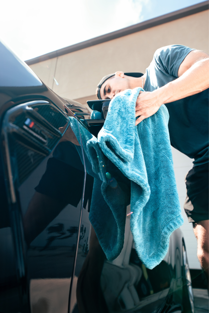 BLACKLINE Twisted-Loop Drying Towel used to dry a glossy black car, turquoise towel in hand on Tampa Home & Garden Store