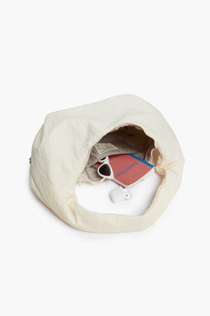 Myra Bag Ivory Shoulder Bag with Circular Handle by Lefrik USA, open to show sunglasses on Tampa Home & Garden Store