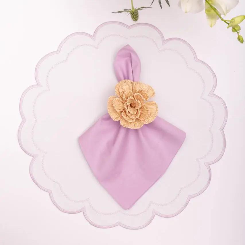 Solid lavender cotton napkin with beige crochet flower accent on a scalloped white plate on Tampa Home & Garden Store