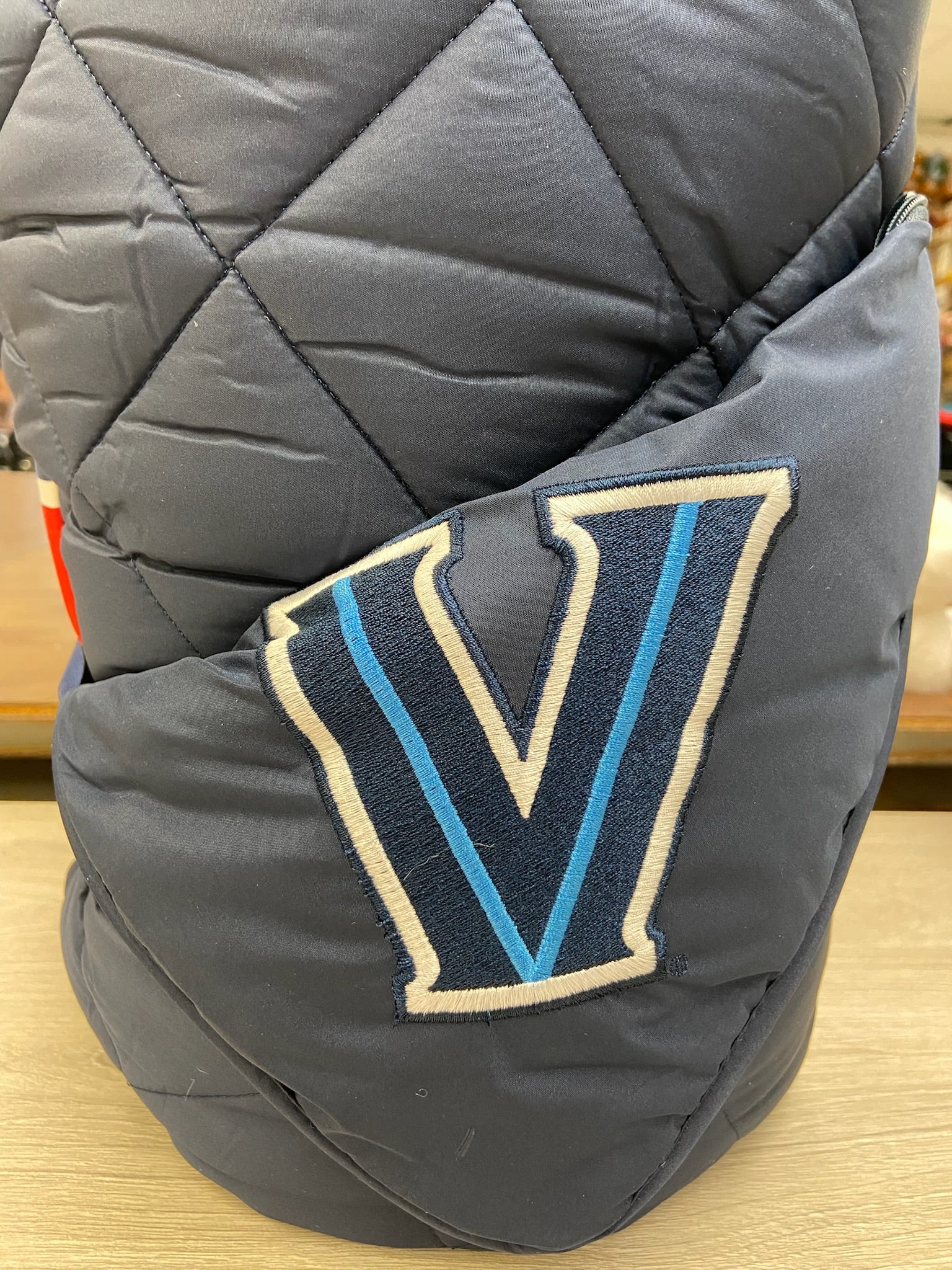 Villanova navy puffer blanket by Pretty Rugged with quilted diamonds and V patch on navy fabric on Tampa Home & Garden Store