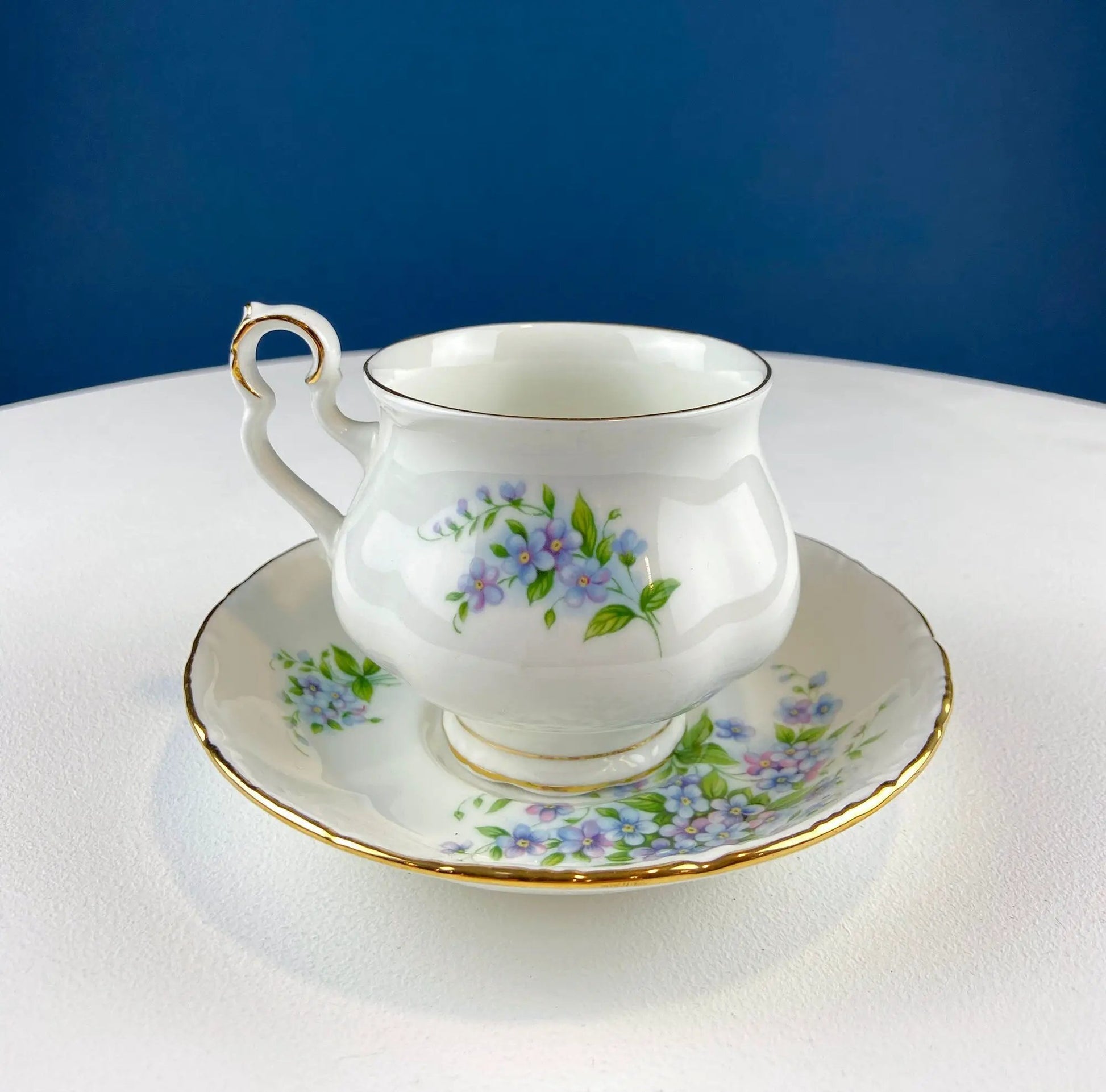 Vintage Forget-Me-Not teacup and saucer with gold rim and floral pattern on white porcelain on Tampa Home & Garden Store