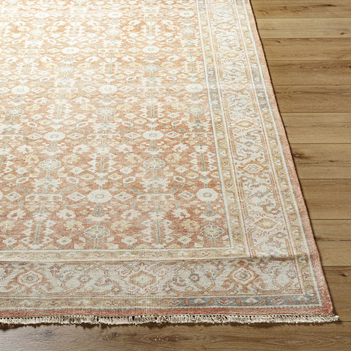 Wailea Area Rug by Boutique Rugs, peach ivory pattern with fringe border on wood floor on Tampa Home & Garden Store