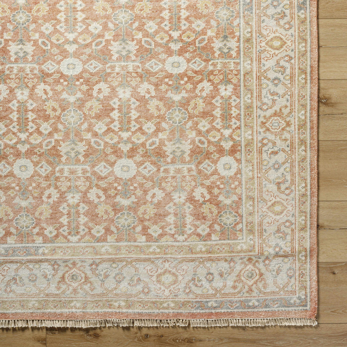 Wailea Area Rug peach ivory with traditional oriental pattern and fringe on wood floor on Tampa Home & Garden Store