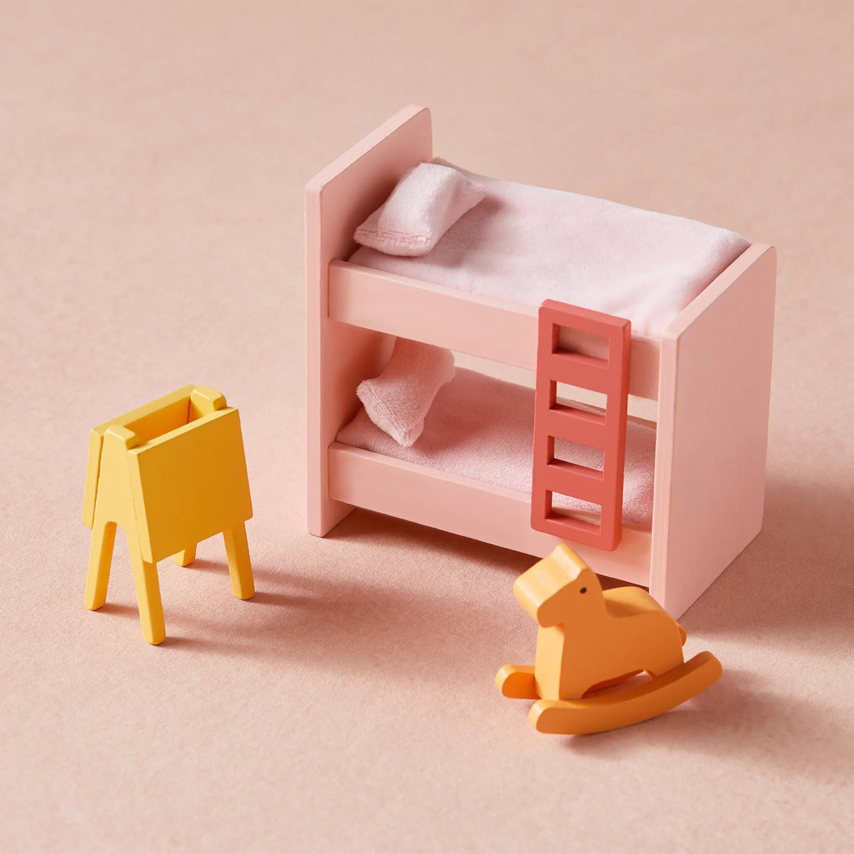 Tiny Land Sweetwood dollhouse bed with pink finish and soft blanket; yellow mini chairs nearby on Tampa Home & Garden Store