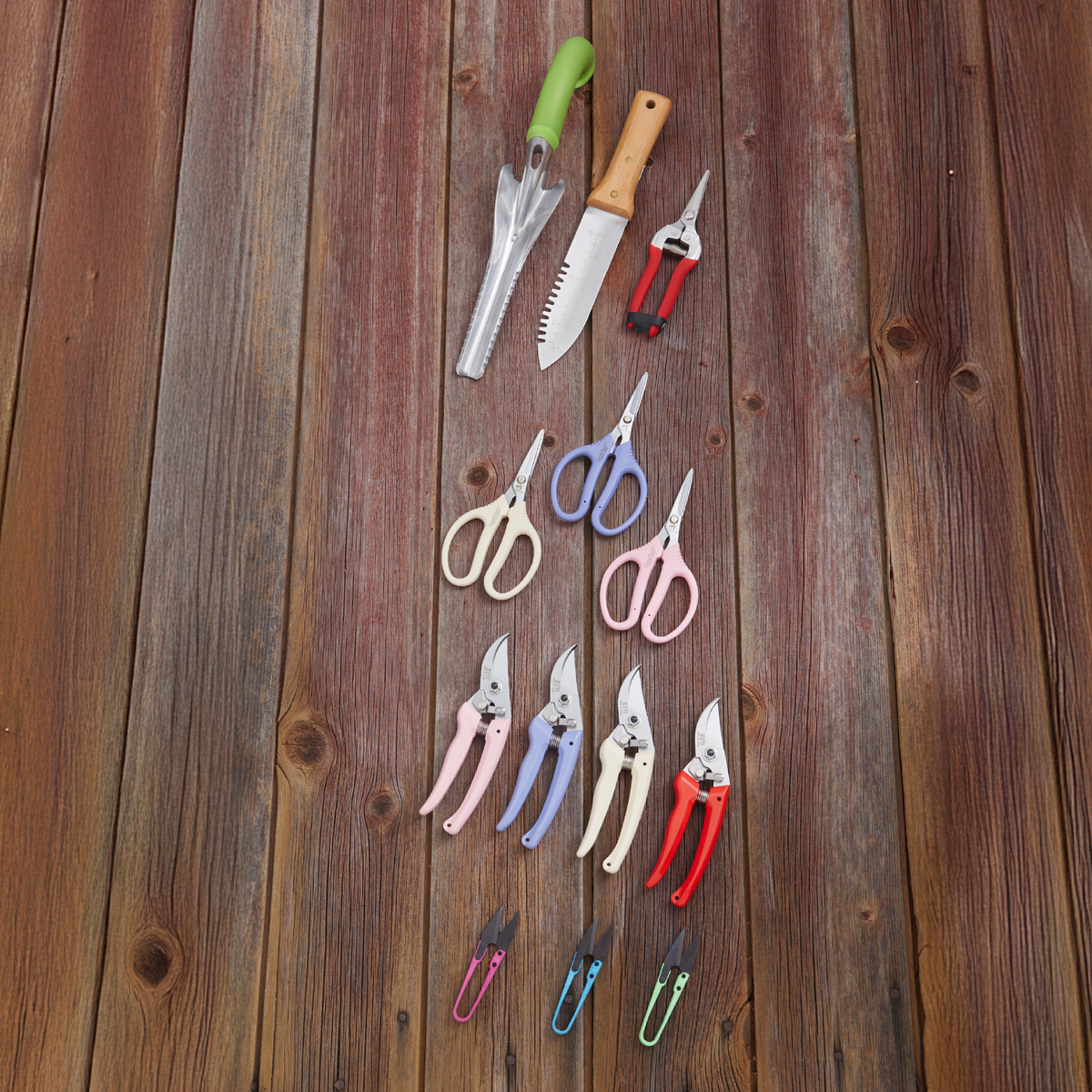 Hori Hori digger with green handle and serrated blade among colorful scissors on Tampa Home & Garden Store