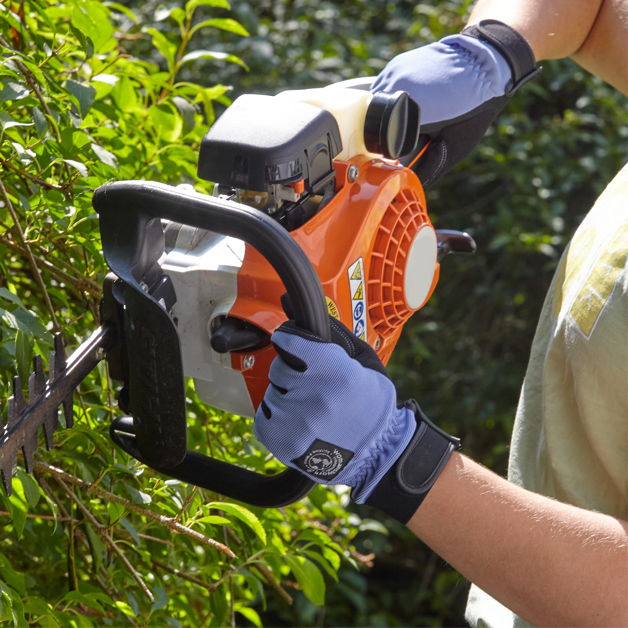 Digger Gardening Gloves by Womanswork, blue gloves gripping an orange hedge trimmer on Tampa Home & Garden Store