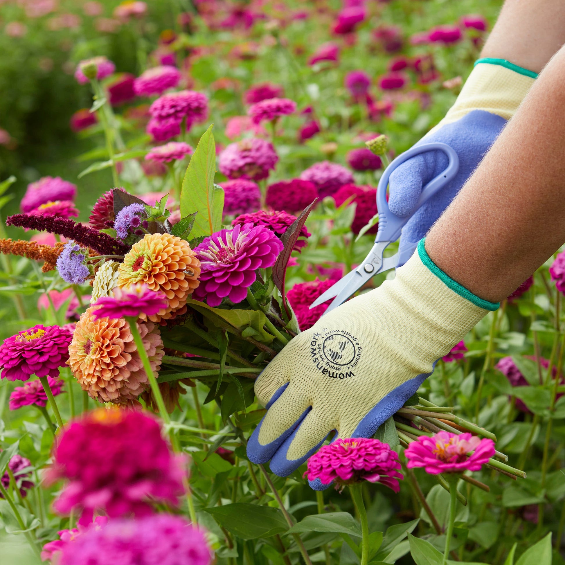 The Weeder Glove by Womanswork; beige glove with blue fingertips and teal trim amid zinnias on Tampa Home & Garden Store