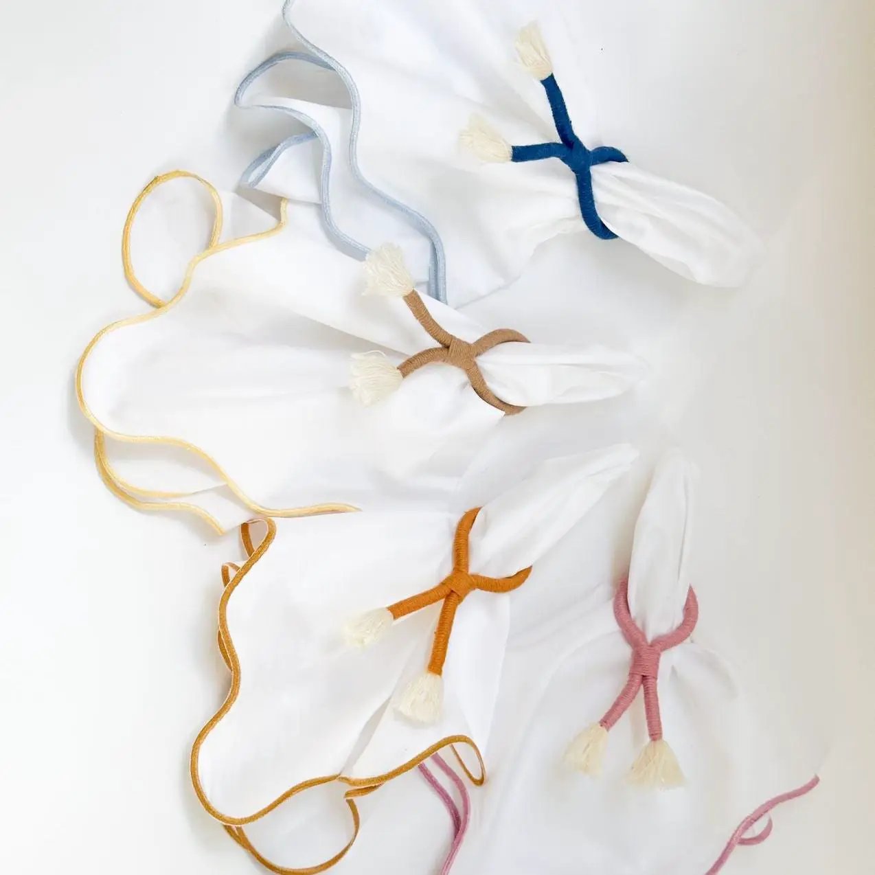 Set of six white cloth napkins with coastal wave trim and colorful tassel ties by Talah Home on Tampa Home & Garden Store