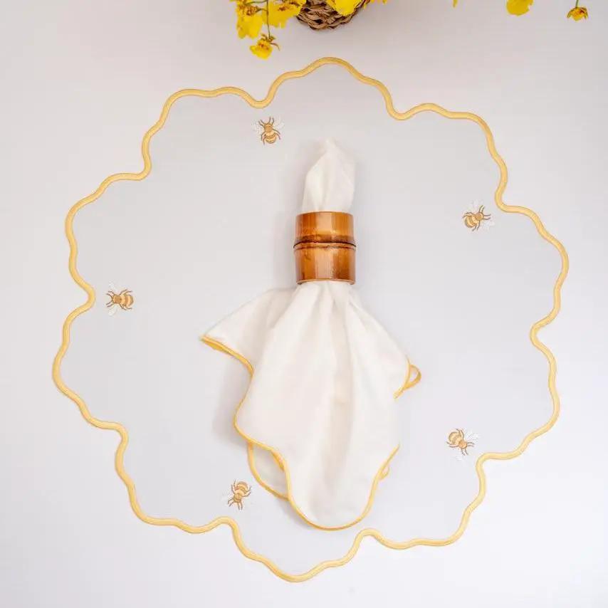 Wave napkin with yellow coastal wave trim on white cloth in a wooden ring by Talah Home on Tampa Home & Garden Store