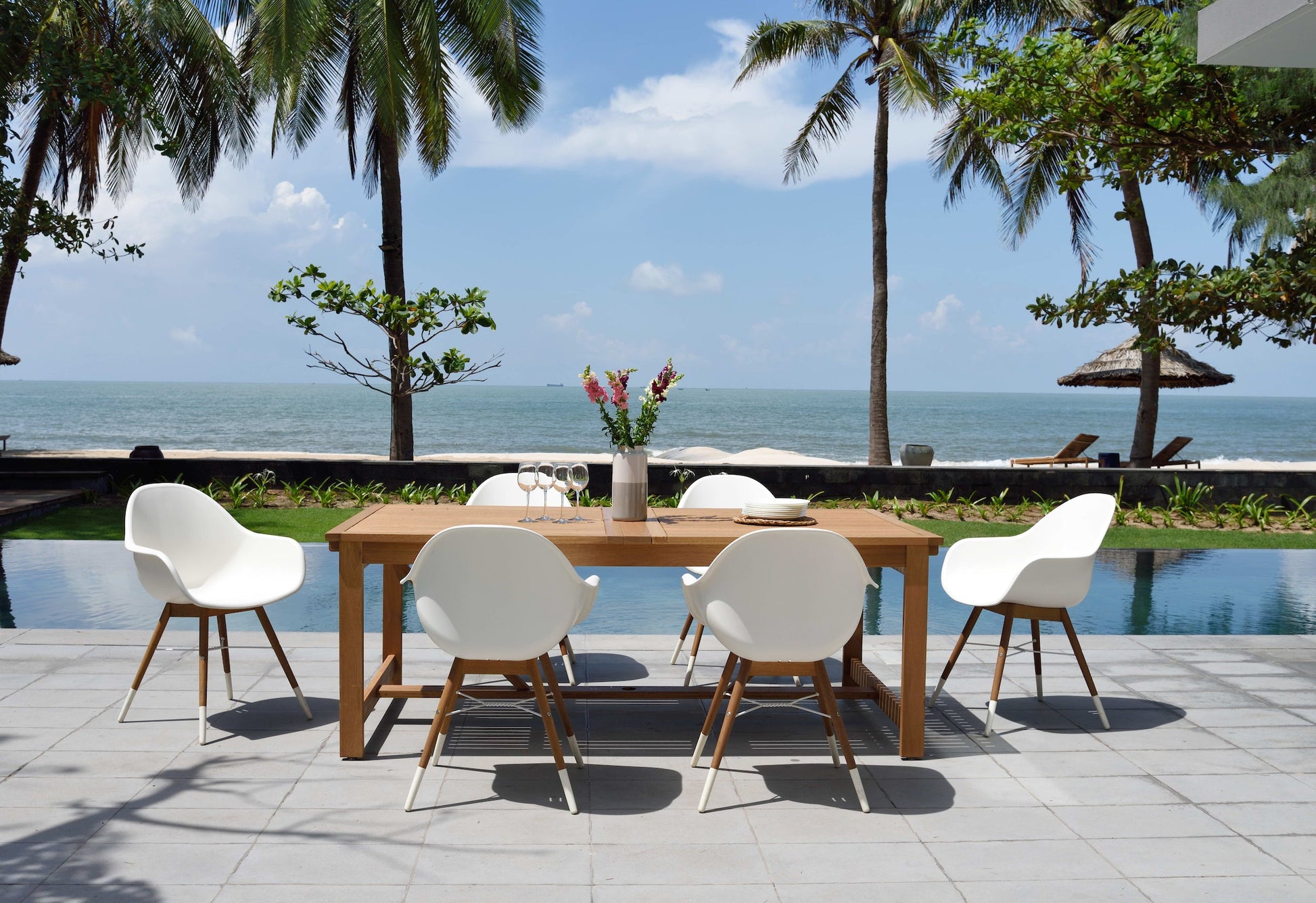 Leyland table with 8 Chamonix armchairs dining set; wooden table, white chairs on seaside patio on Tampa Home & Garden Store