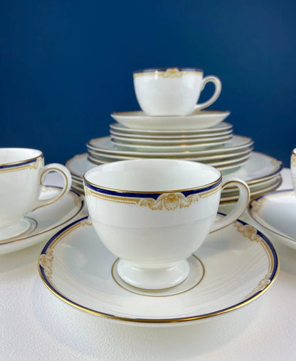 Wedgewood Cavendish teacup atop stacked dinner plates with gold and blue trim porcelain on Tampa Home & Garden Store