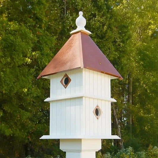 White two-story Songbird Birdhouse with copper roof and two tiers, diamond holes, on a post on Tampa Home & Garden Store