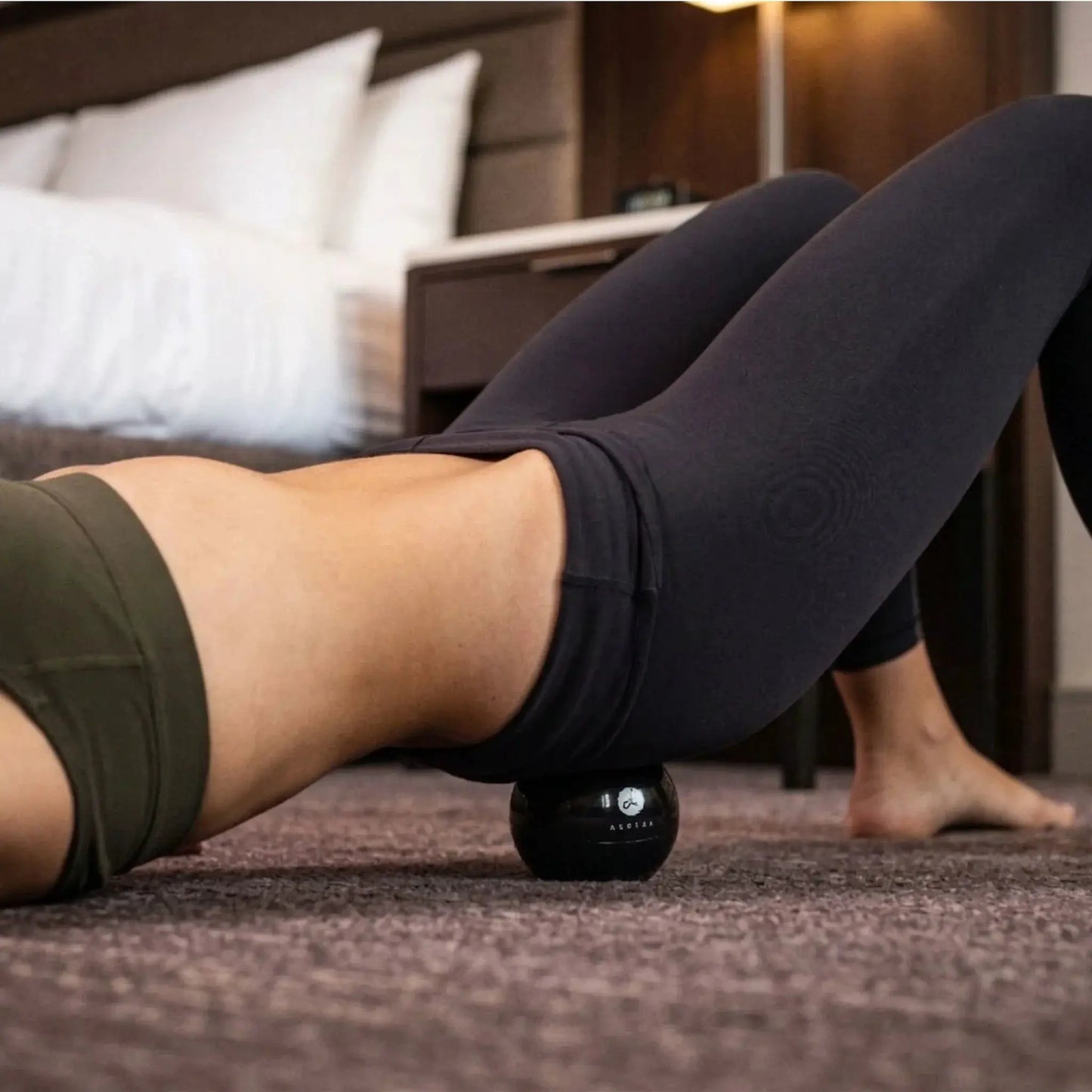 Full Body System muscle release tool by Aletha Health, black massage ball under leg on carpet on Tampa Home & Garden Store