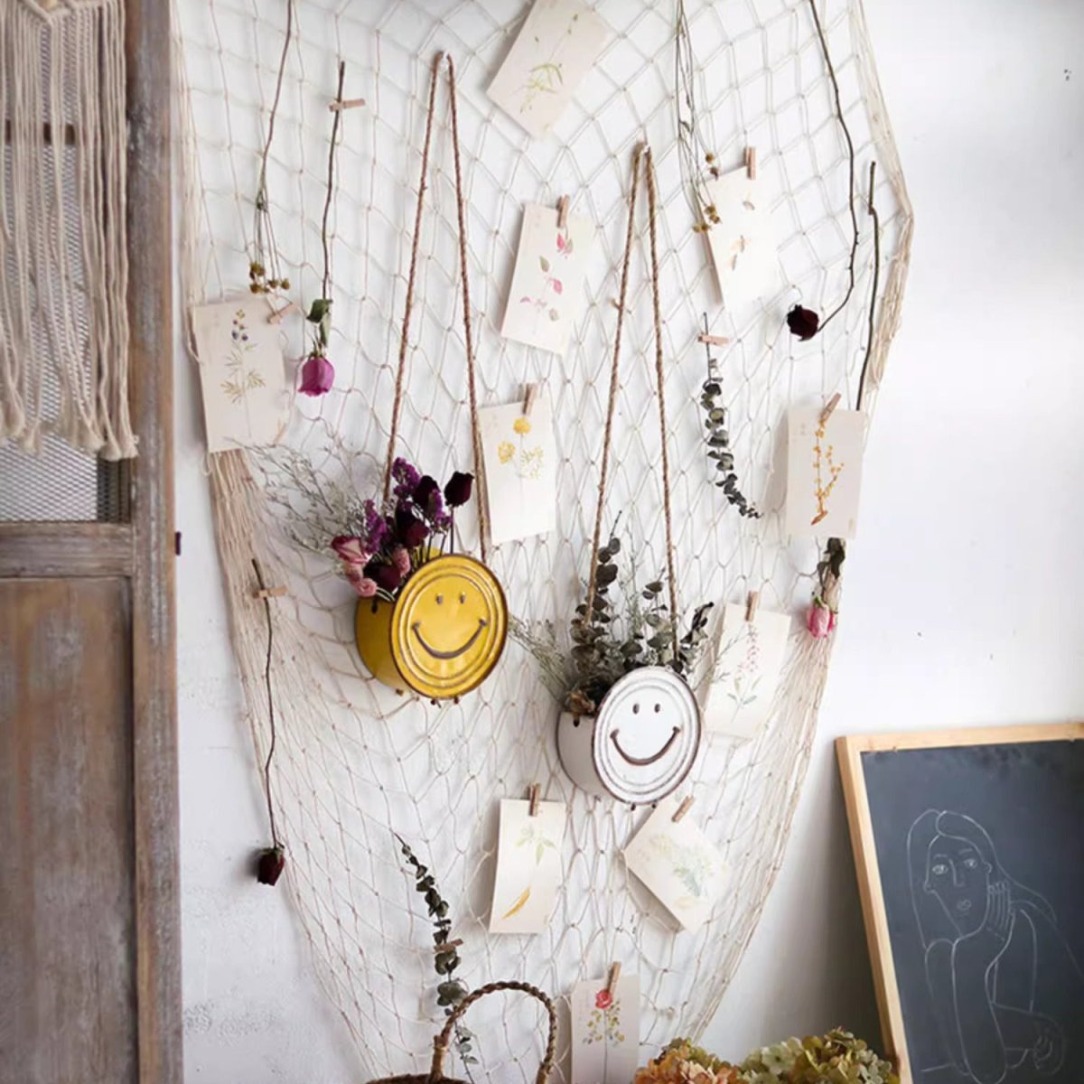 Happy Face Hanging Planters; yellow and white smiley rope-hung planters on a net backdrop on Tampa Home & Garden Store