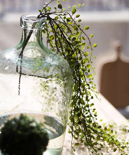 Hanging faux mini leaf garland, 27.5in, green leaves draped over a glass bottle on Tampa Home & Garden Store