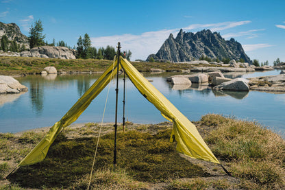 Trekker Palace 2-Person Backpacking Tent bright yellow pitched by lake with rocky cliffs on Tampa Home & Garden Store