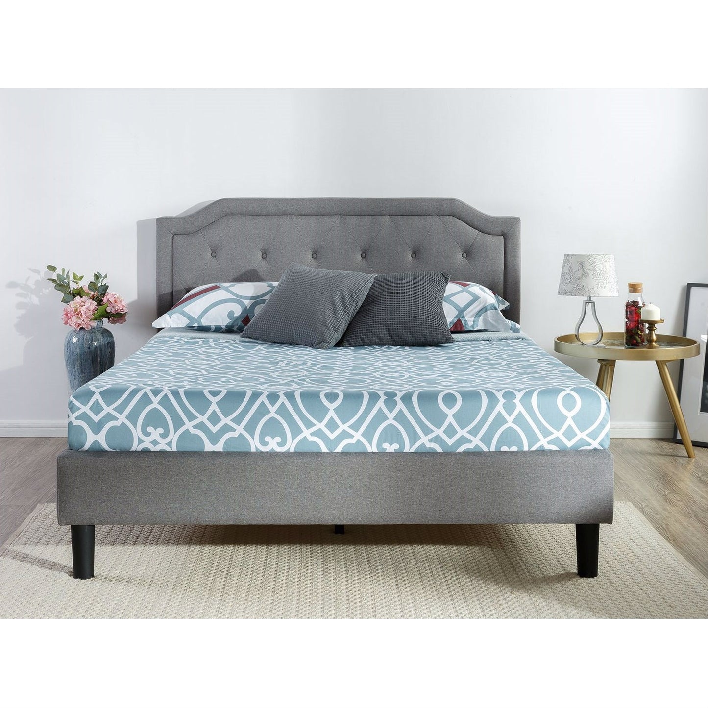 Cama king size con plataforma tapizada en gris y cabecero clásico con botones capitoné