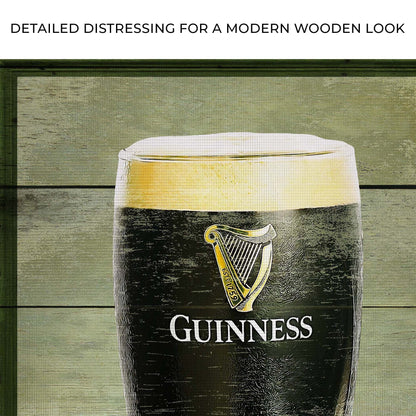 Canvas sign featuring Guinness harp logo on black bottle label atop green wood backdrop on Tampa Home & Garden Store