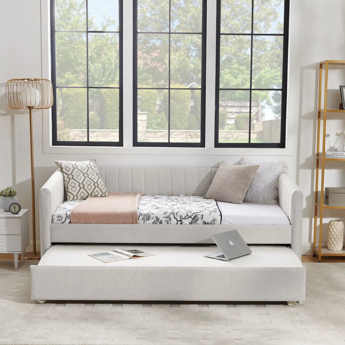 Upholstered gray daybed with pull-out trundle, featuring patterned pillows and a soft throw on Tampa Home & Garden Store