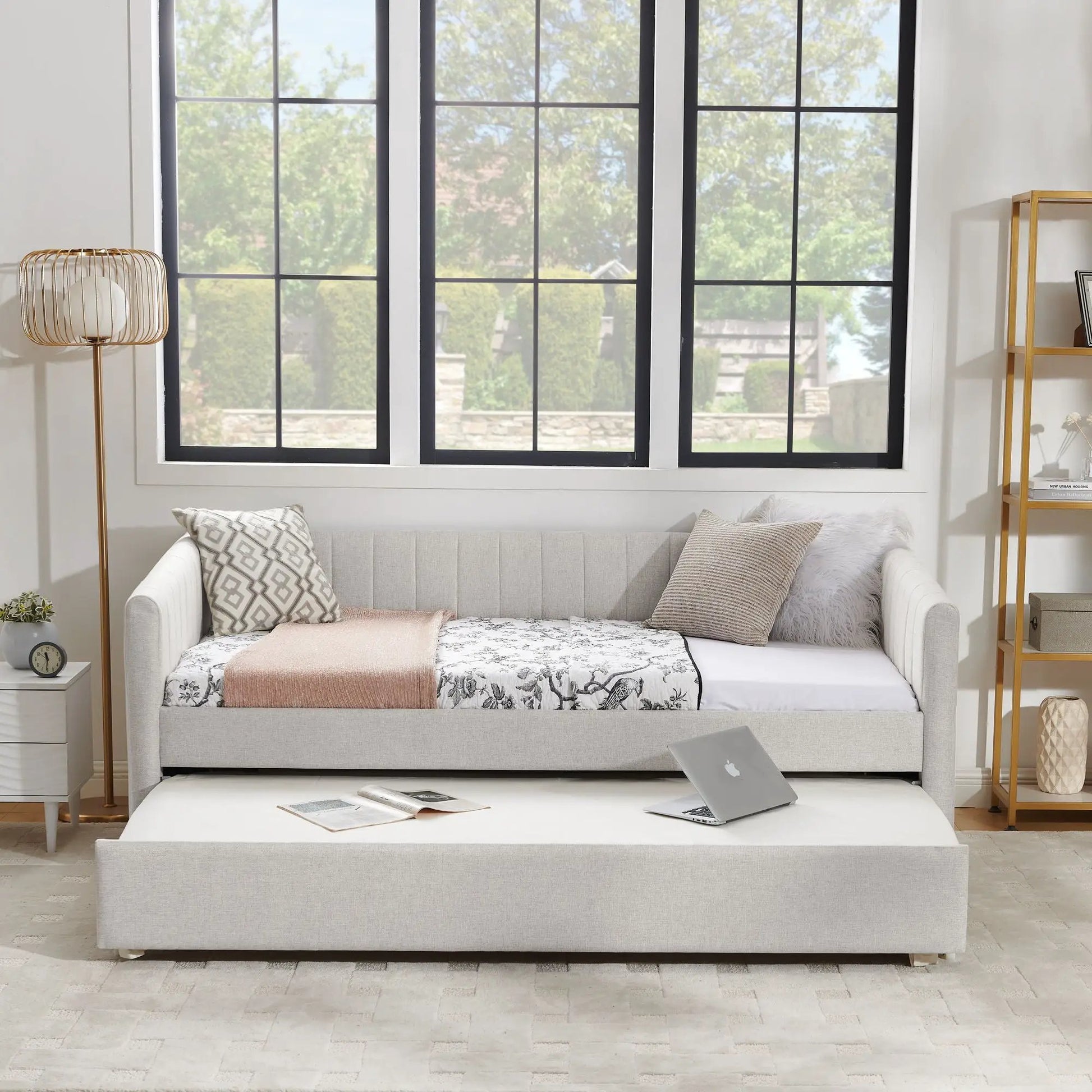 Upholstered gray daybed with pull-out trundle, featuring patterned pillows and a soft throw on Tampa Home & Garden Store