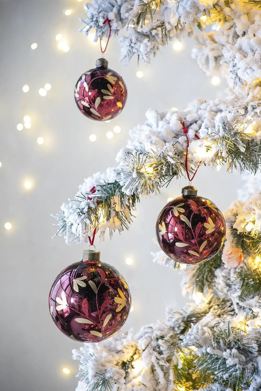 Glass burgundy Christmas ball ornament set of 3 with gold leaf pattern on a snow-dusted tree on Tampa Home & Garden Store