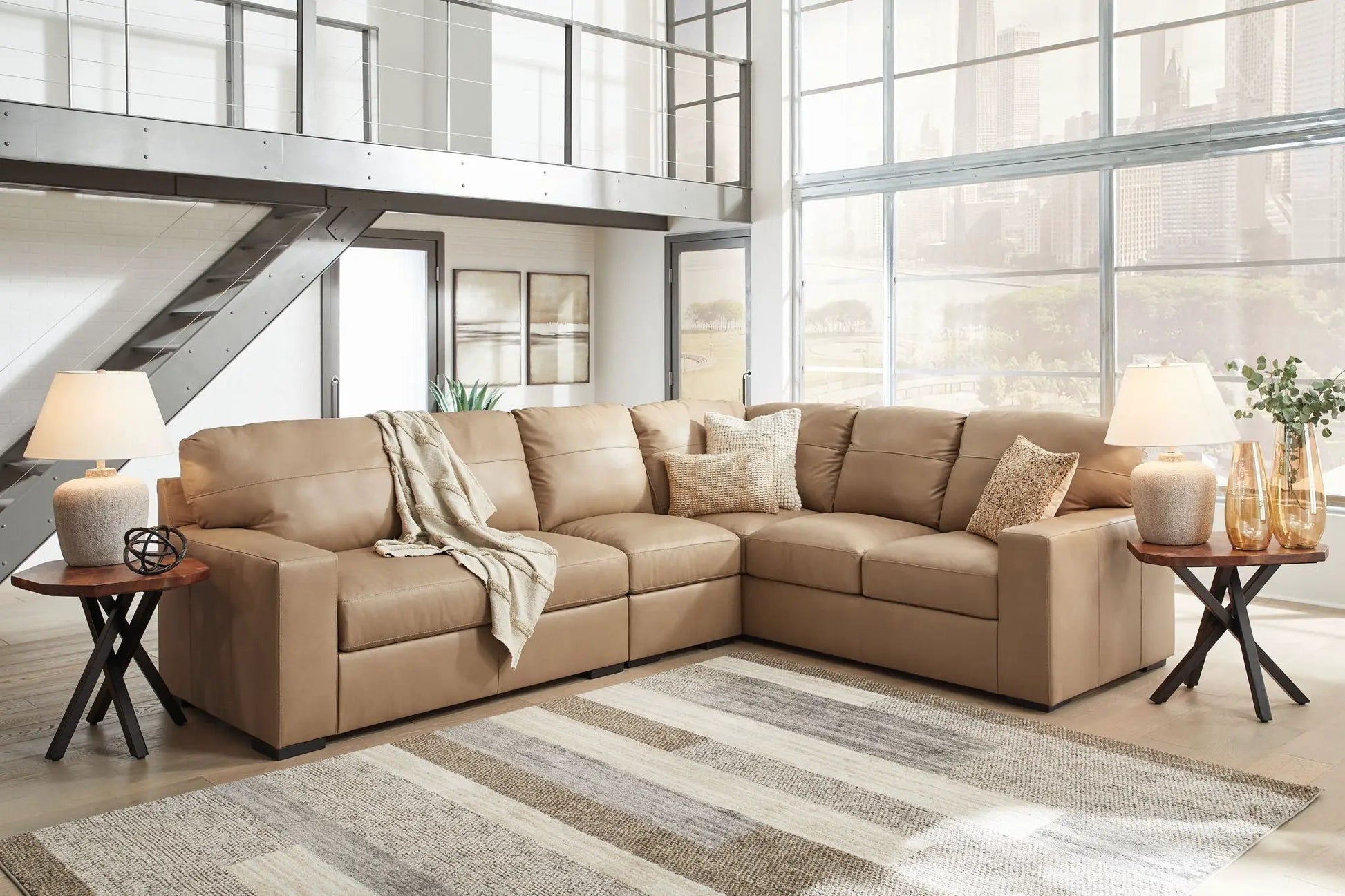 Bandon stationary sectional tan leather with beige pillows in a bright modern living room on Tampa Home & Garden Store