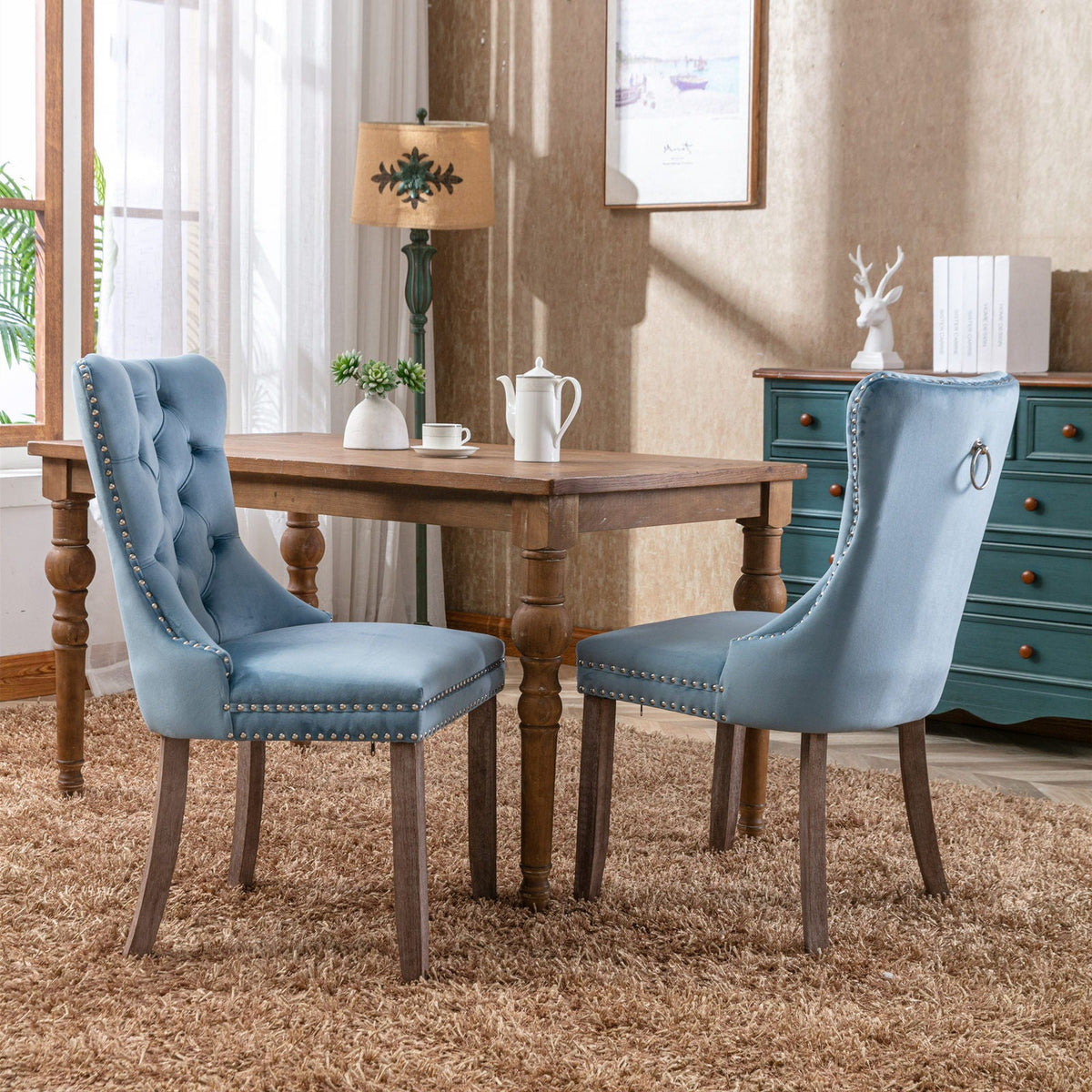 Two blue velvet tufted dining chairs with nailhead trim and wooden legs on Tampa Home & Garden Store