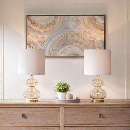 HouseOfZazla lamp pair with clear glass bodies, brass bases, shades on a wooden dresser on Tampa Home & Garden Store