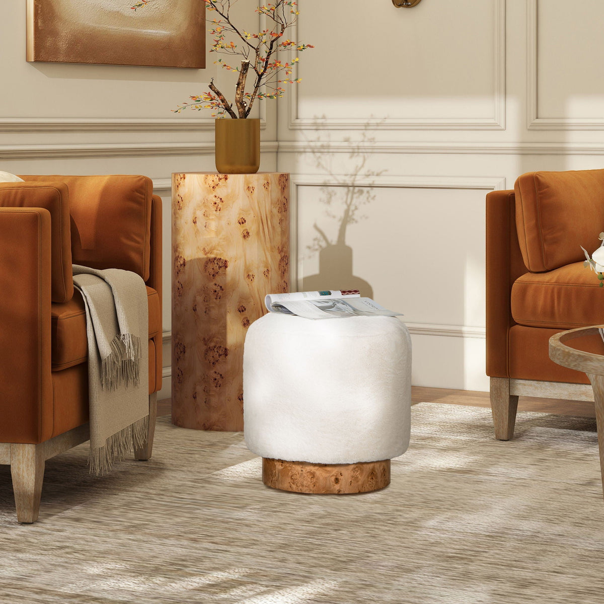 Round white fur pouf ottoman with burl base in living room beside caramel leather chairs on Tampa Home & Garden Store