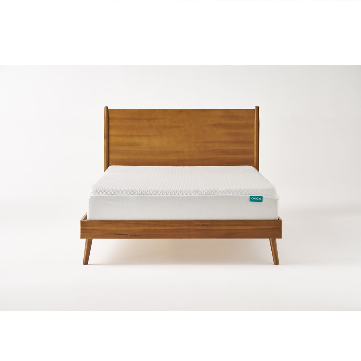 Mid-century wooden platform bed in light brown with white mattress and teal OkiOkI tag on Tampa Home & Garden Store