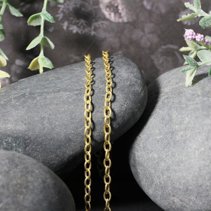 3.5mm 14k yellow gold textured-link chain necklaces, two pieces, hanging on gray stones on Tampa Home & Garden Store
