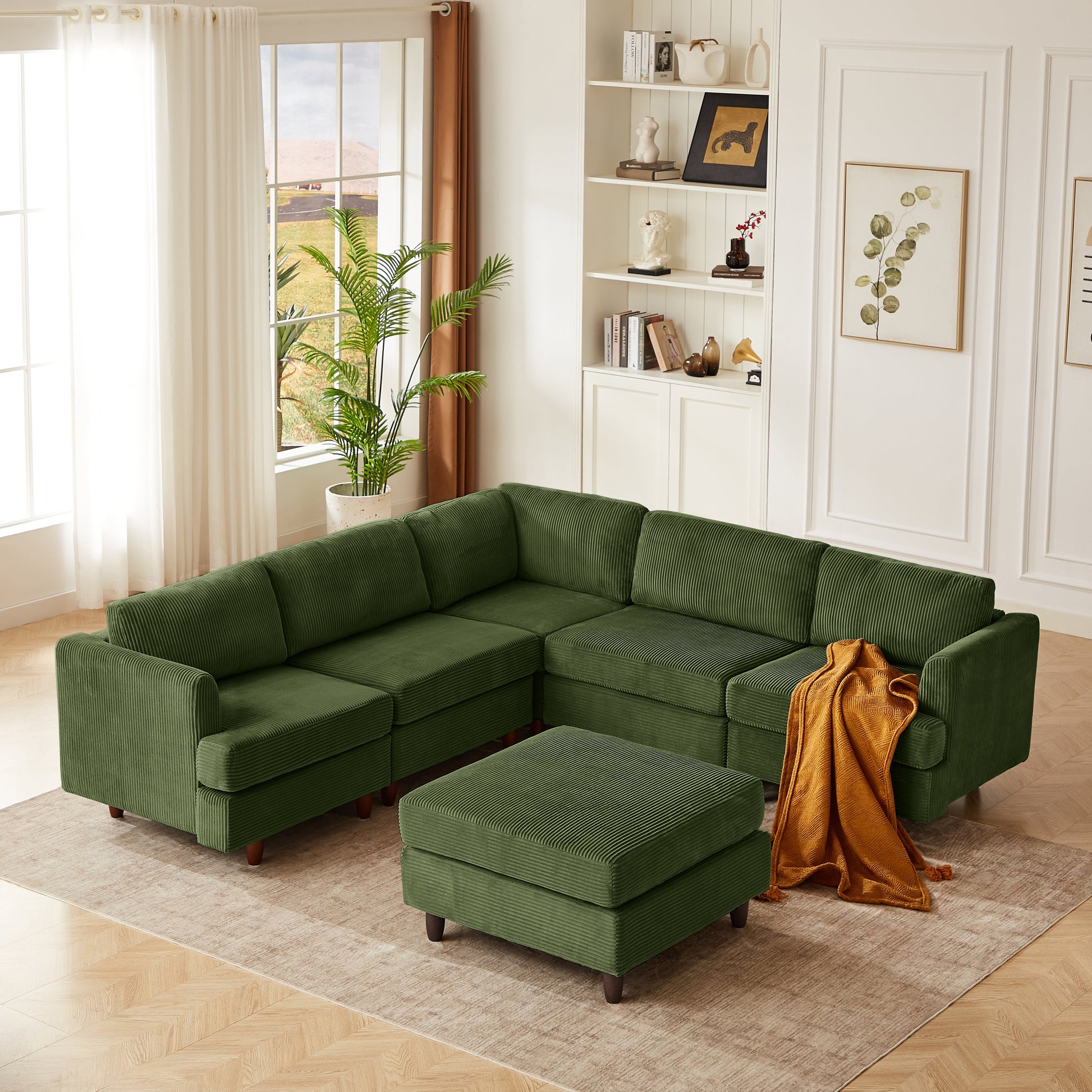 Modern modular sectional couch in green with ottomans, white shelves, sunlit window on Tampa Home & Garden Store