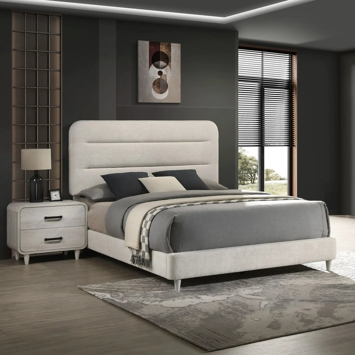 Nightstand with 2 drawers in antique white wood finish beside a grey upholstered bed on Tampa Home & Garden Store