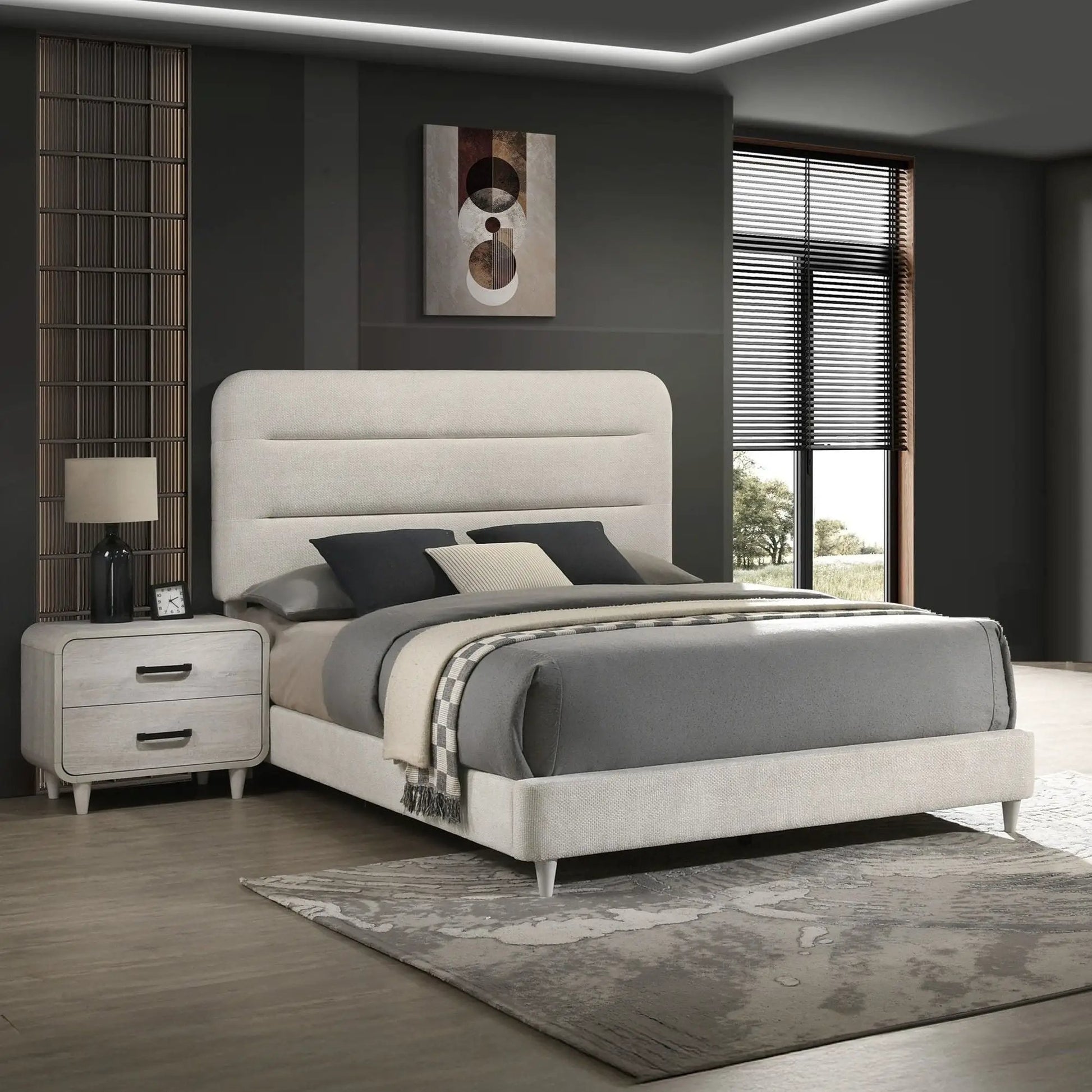 Nightstand with 2 drawers in antique white wood finish beside a grey upholstered bed on Tampa Home & Garden Store