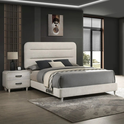Nightstand with 2 drawers in antique white wood finish beside a grey upholstered bed on Tampa Home & Garden Store