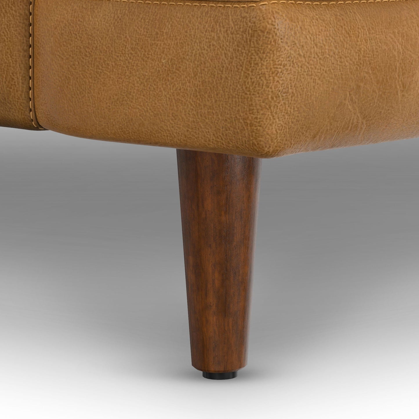 Livingston upholstered sofa bottom edge in tan textured fabric with dark wooden leg on Tampa Home & Garden Store