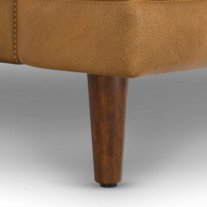 Livingston upholstered sofa bottom edge in tan textured fabric with dark wooden leg on Tampa Home & Garden Store