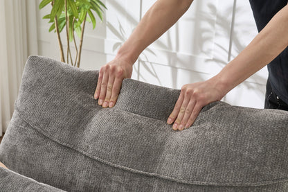 Modern grey upholstered chaise lounge sofa recliner in textured fabric with hands pressing edge on Tampa Home & Garden Store