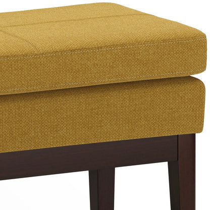 Carlson Ottoman Bench mustard yellow woven fabric with white stitching on dark wood legs on Tampa Home & Garden Store