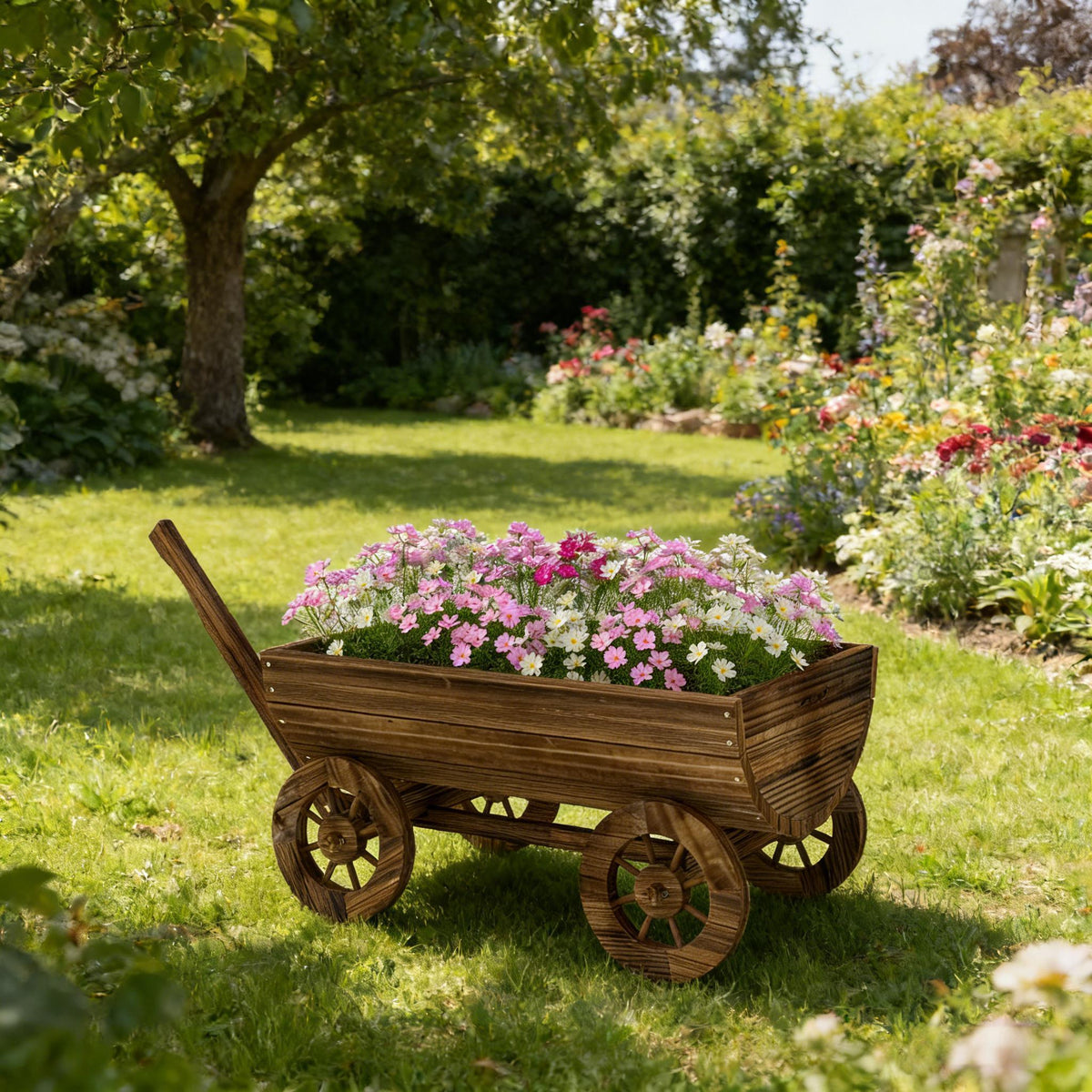 Small wooden wheelbarrow planter filled with pink and white daisies in a sunny garden on Tampa Home & Garden Store