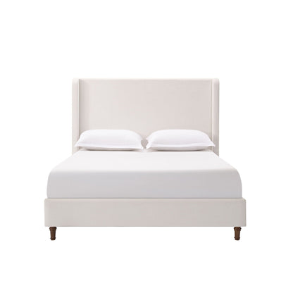 Harper tall upholstered bed with beige fabric headboard, white sheets and two pillows on Tampa Home & Garden Store