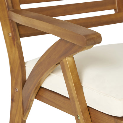 Outdoor acacia wood dining chair with cream cushion and crossbar legs on Tampa Home & Garden Store
