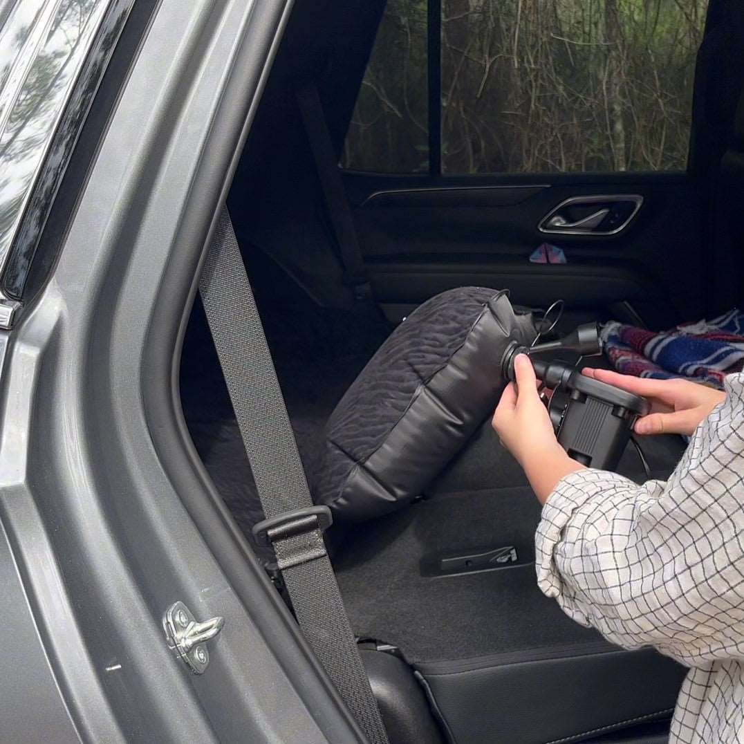 Umbrauto SUV air mattress 1.0 in black, being inflated in rear cargo area with hand pump on Tampa Home & Garden Store