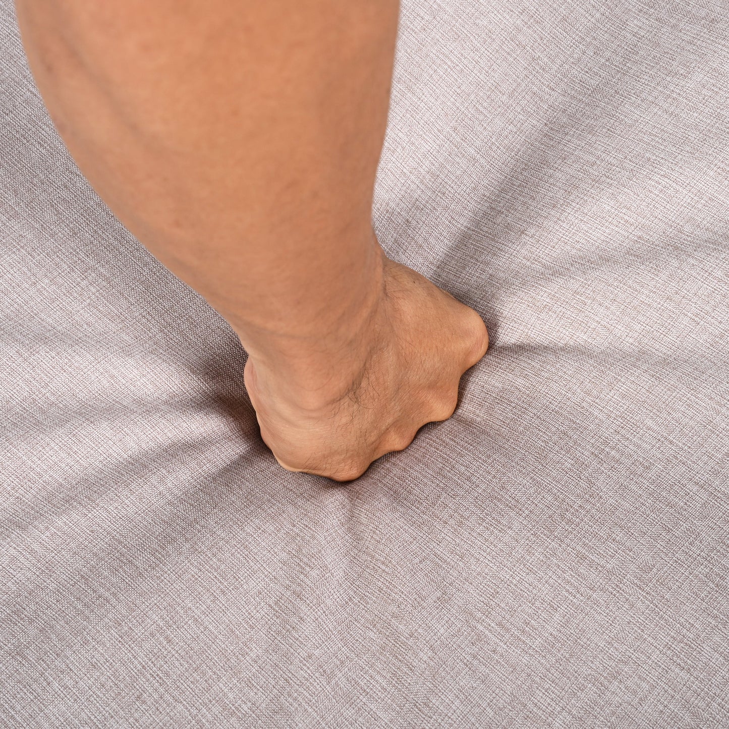 Outdoor Chaise Lounge Chair close-up of a tan leg resting on beige textured fabric surface on Tampa Home & Garden Store