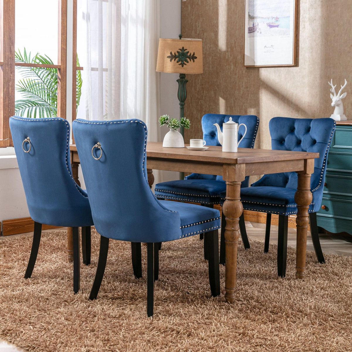 Tufted velvet dining chair set in blue with nailhead trim and ring-pull backs around a table on Tampa Home & Garden Store